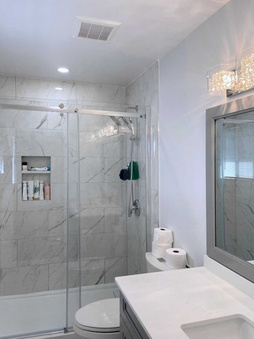 Glass shower bathroom. A modern bathroom design and renovation, glass shower enclosure, tempered glass, handles and mounting hardware, ceramic tiles, tile flooring, faux marble or stone tile flooring and walls. A London Ontario bathroom and shower renovation project by Brothers Construction 3 Inc.